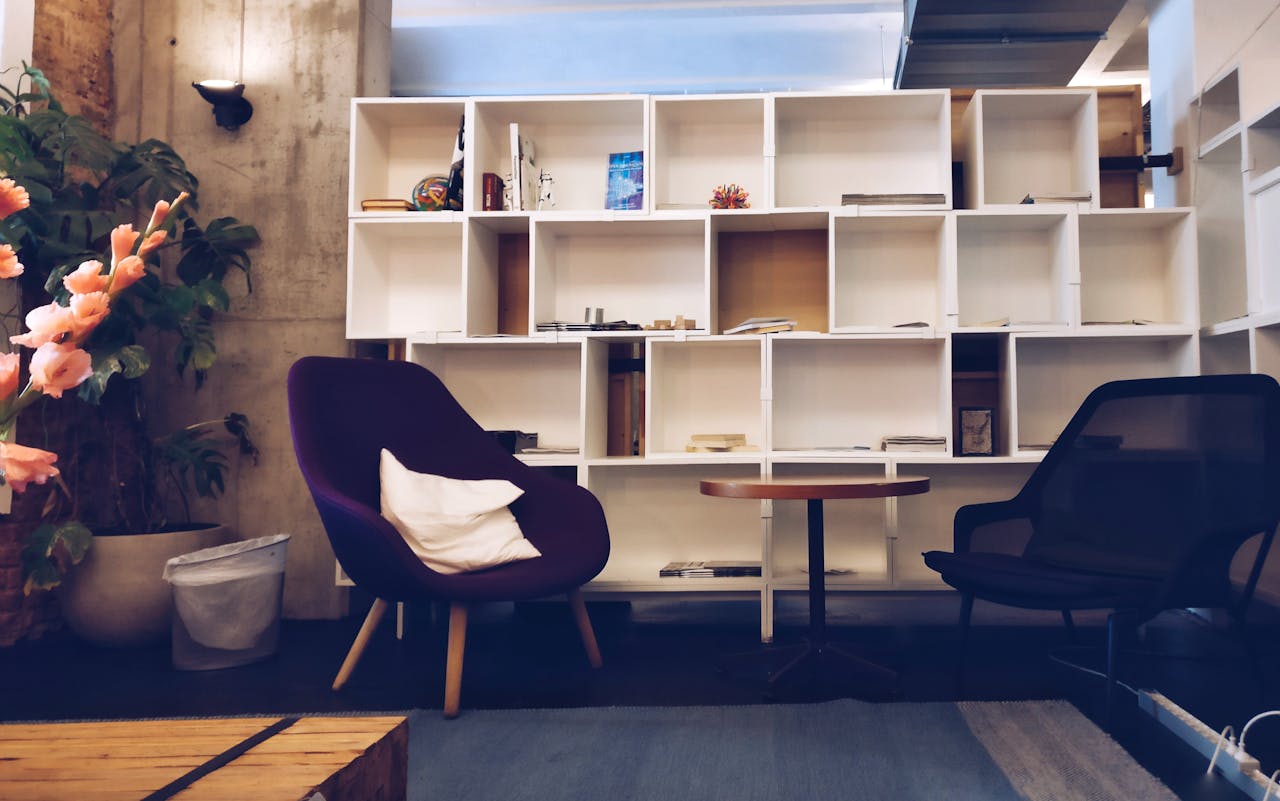 about-us A stylish living room featuring modern furniture, bookshelves, and decorative plants.